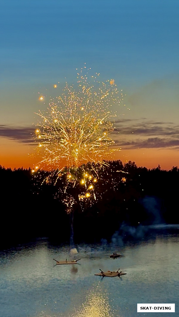 Красочный салют, над вечерней гладью озера.