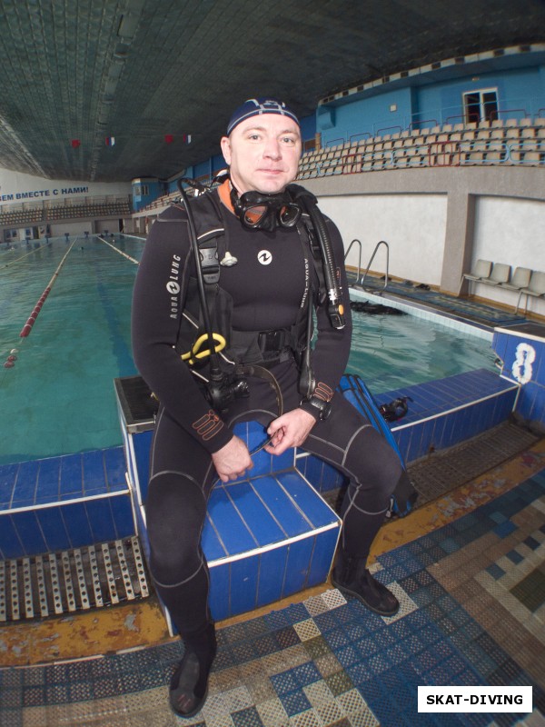 Ардашев Максим, обученный аквалангист спокойно сидит на тумбочке, ожидая пока инструктор закончит заниматься женой