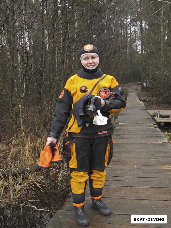 Харитонова Оксана, в ярком желтом костюме на фоне однотонного зимнего леса