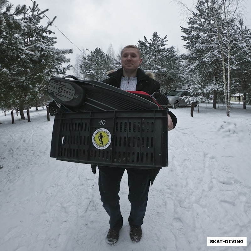 Чмутов Сергей, выгружает снаряжение на веранду у дома